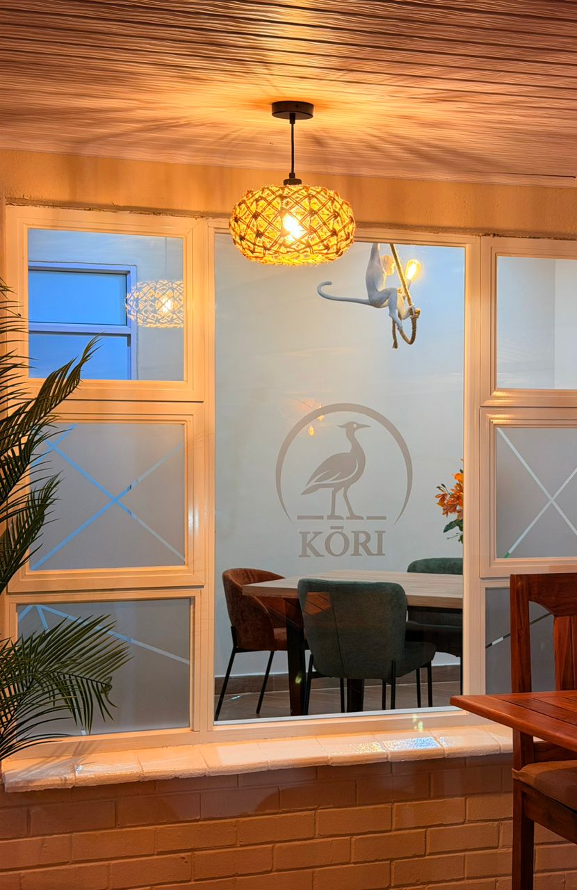 Kori Studio interior — frosted logo window with monkey chandelier and woven pendant light
